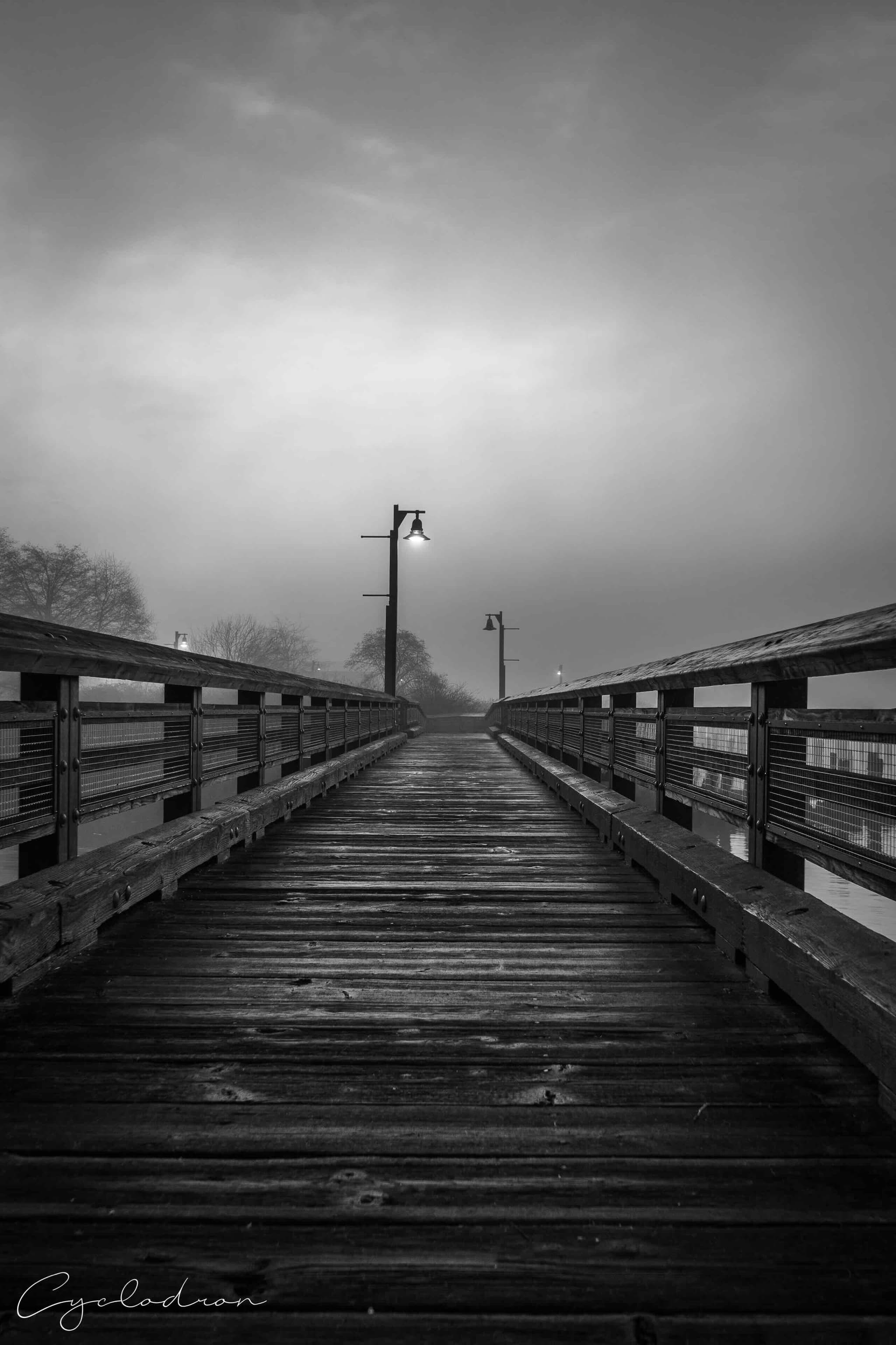 Black and white foggy boardwalk perspective with dramatic leading lines