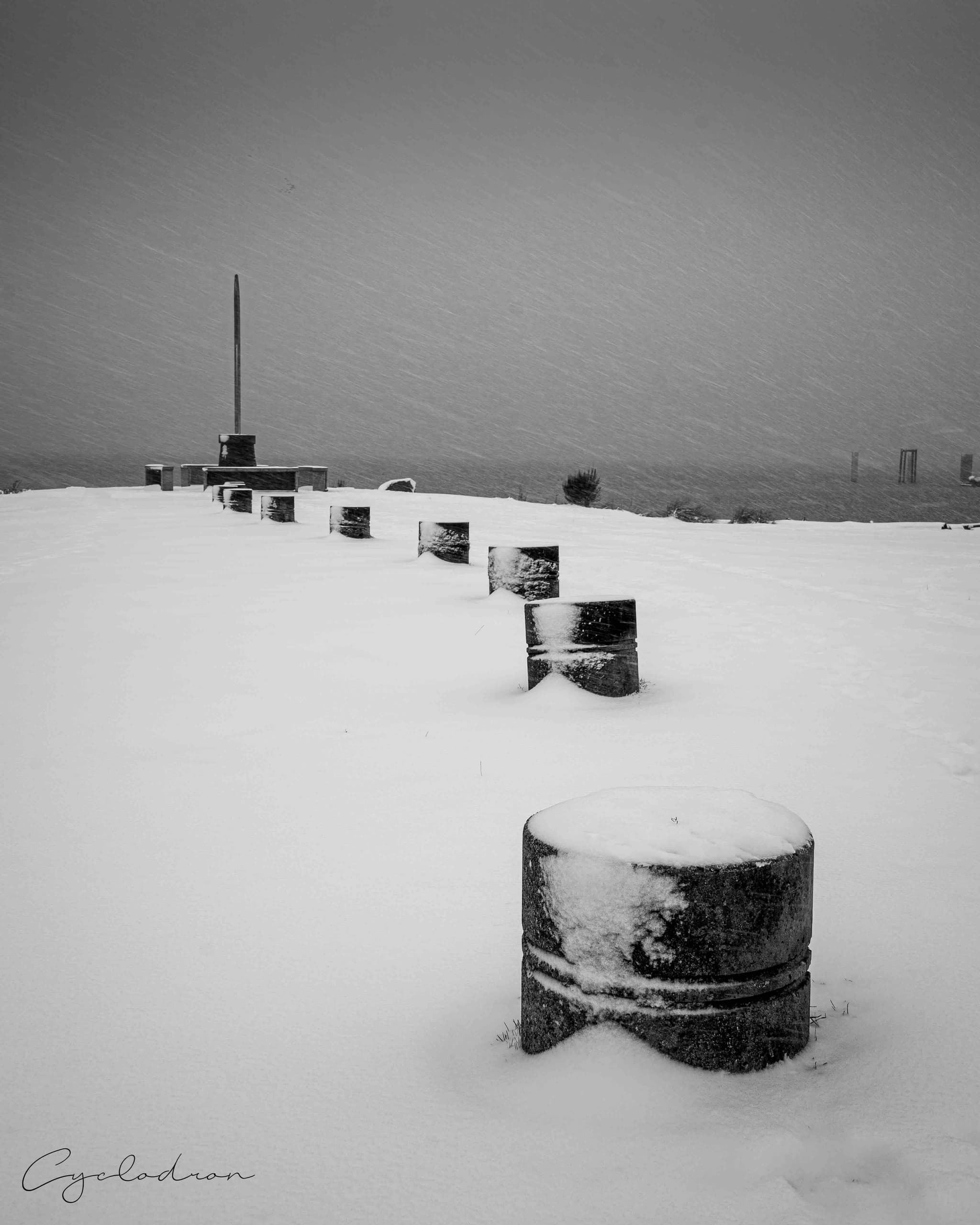 Black and white minimalist winter monument scene with snow-covered posts
