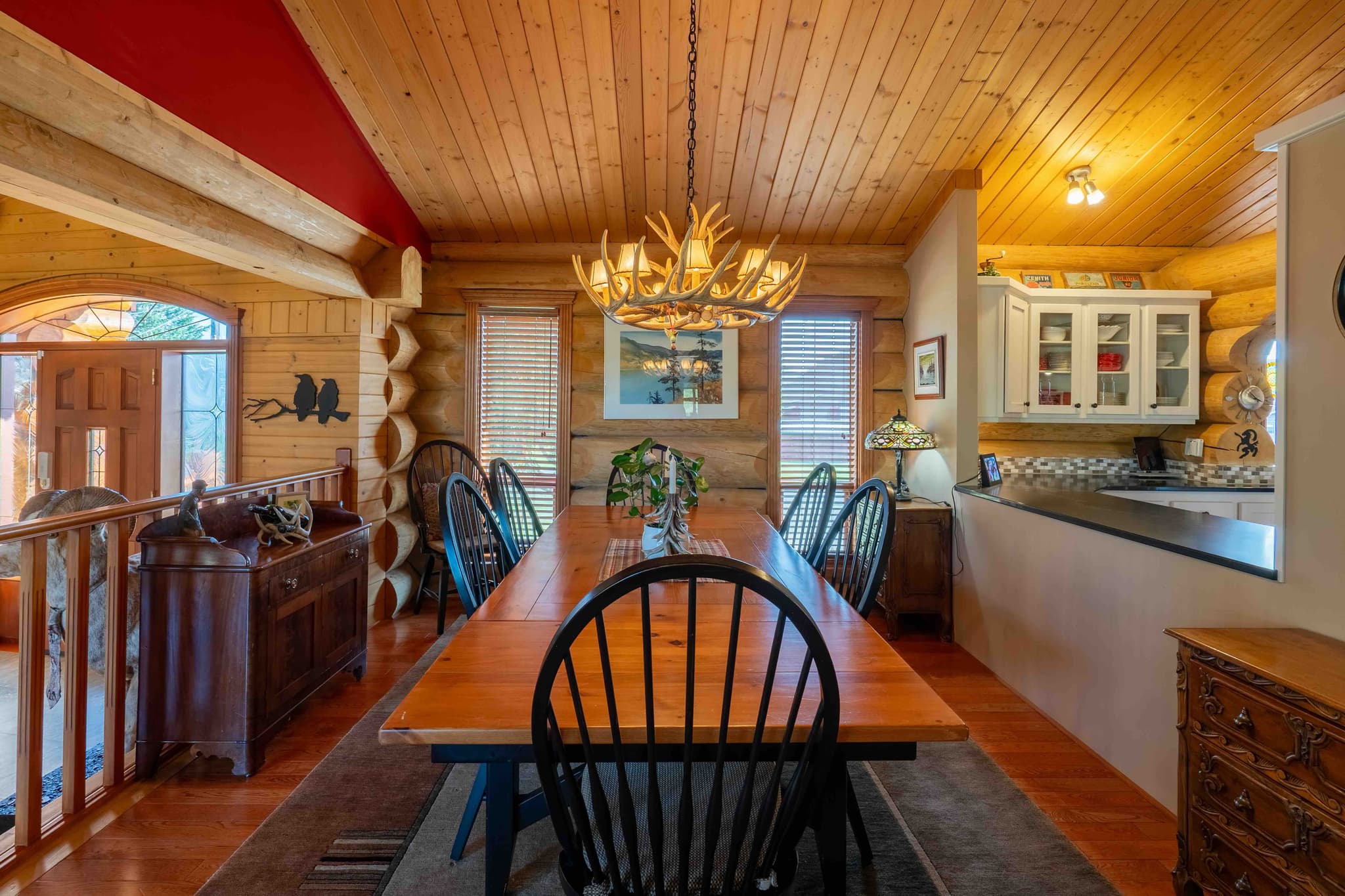 Log cabin dining area with wood table and antler chandelier