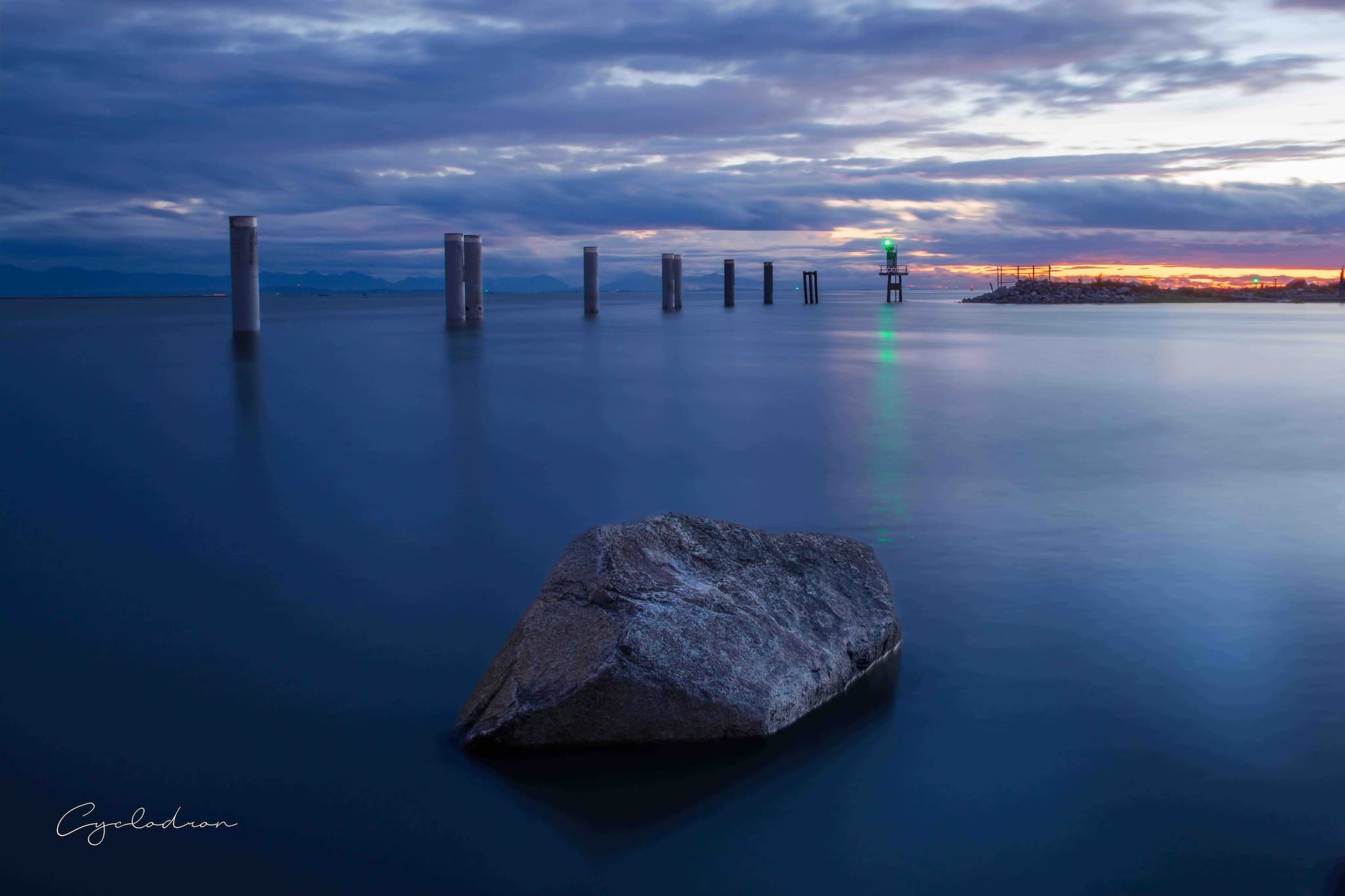 Blue hour seascape with lighthouse and calm water